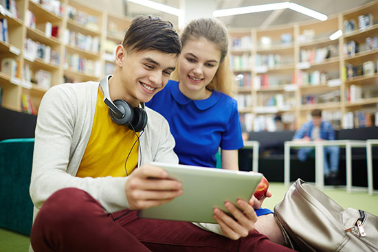 Teens using tablet in a library